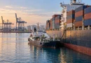 Контейнеровоз бункерова гориво от бункеровъчен кораб в пристанище.